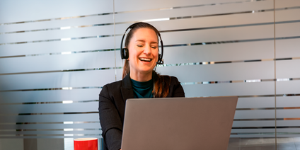 Frau mit Headset am Laptop im Büro Frau mit Headset am Laptop im Büro