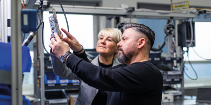 Metallbauteilprüfung im industriellen Umfeld Fachkräfte prüfen Metallbauteil gemeinsam