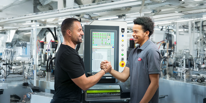 Teamwork vor industrieller Steuerungseinheit Zwei Mitarbeiter vor Steuerungsgerät